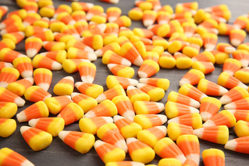 Colorful Halloween candy corns on wooden background