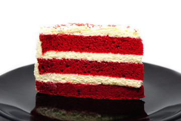 Cut cake Red velvet chocolate on black plate isolated on white background