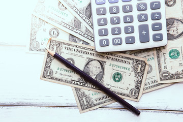 Calculator with american dollars on the wooden table background, finance concept