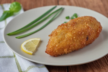 Chicken cutlets with mushrooms and vegetables on a wooden background
