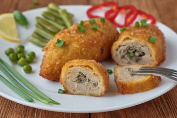 Chicken cutlets with mushrooms and vegetables on a wooden background