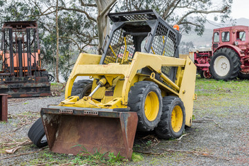 yellow excavator on a grader parked
