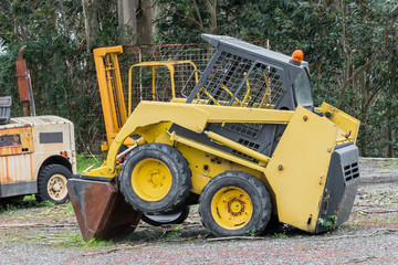 yellow excavator on a grader parked