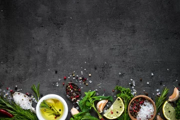 Fotobehang Aroma Selectie van kruiden, kruiden en greens. Rozemarijn basilicum citroen olijfolie peper bovenaanzicht zwarte achtergrond.