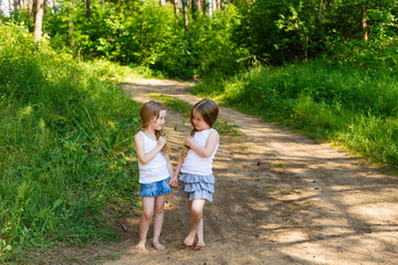 Fototapeta premium Two little girl girl friends hugging in the forest