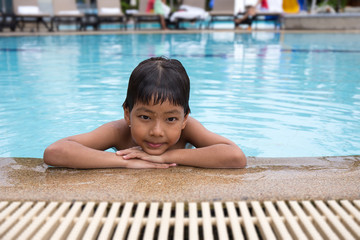 8 years old Asian kid swimming lonely in clean swimming pool at sport club