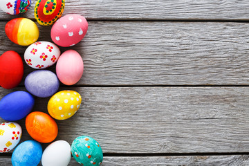 Naklejka premium Colorful easter eggs on wood background