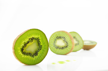 Ripe and juicy kiwi fruit and its parts on a white background