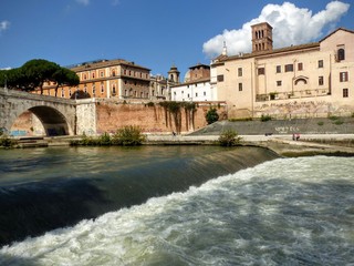 Fiume mosso sulla riva dell' Isola Tiberina a Roma in Italia.