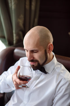Beautiful male drinking cognac.