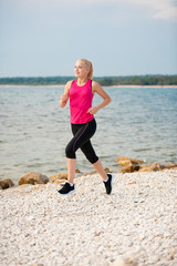 jogging in th beach - woman runns near sea on early summer morning