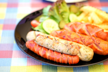 Sausage fried and french fries with vegetables on chintz.