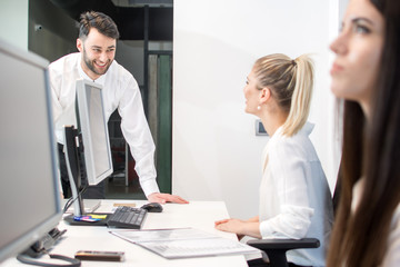 Obraz premium Młody przystojny biznesmen rozmawia z recepcjonistką.