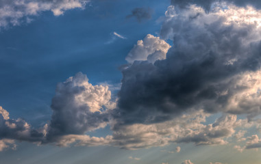 Fototapeta na wymiar Cumulus clouds with rays of sun