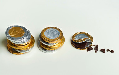 Stacked chocolate euro coins on white background, investment concept