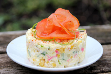 Salad, tomato and greens on a wooden table