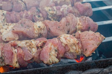 Skewers of pork on the coals with smoke. BBQ