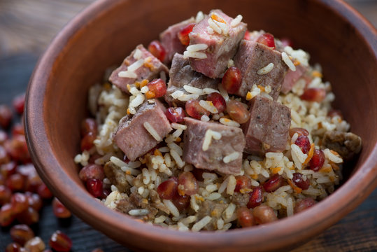 Closeup of pilaf cooked in georgian style with beef meat and pomegranate, shallow depth of field