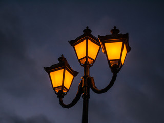 Fototapeta na wymiar night old-fashioned lantern on the backdrop of a gloomy sky