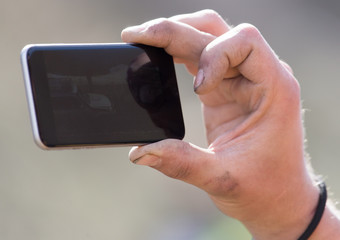 The hand with the phone shoots video