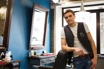 Barber invites to have seat on chair at barbershop