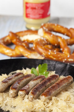 N&uuml;rnberger Bratwurst auf Kraut in einer Pfanne
