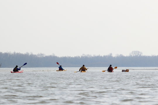Guys in four kayaks in winter Danube river. Winter kayaking