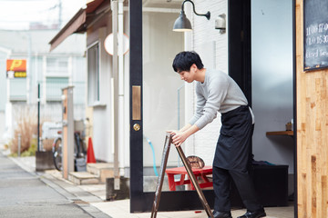 看板を出すカフェ店員