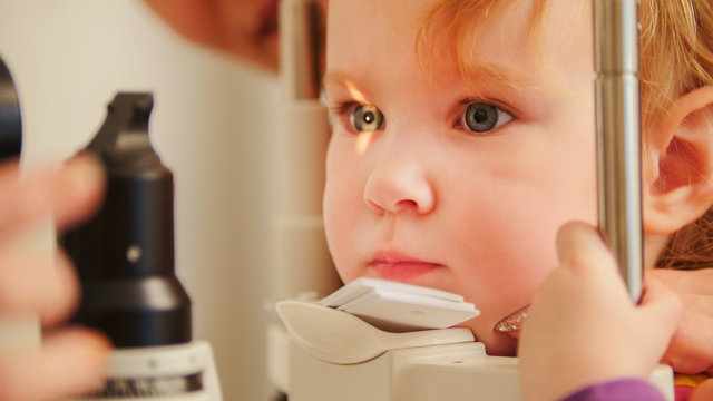Child's optometry concept - little girl checks eyesight in eye ophthalmological clinic