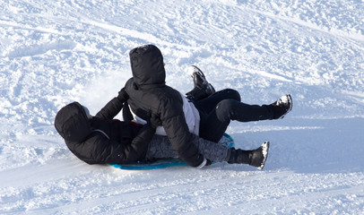 Fototapeta na wymiar two guy riding the hills on sleds