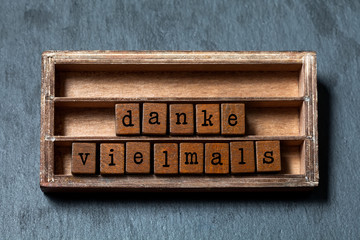 Danke vielmals. Thank you very much or great thanks in German translation. Vintage box, wooden...