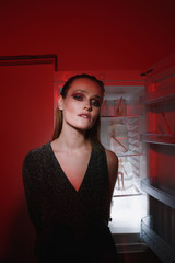 Vertical photo of sensual young woman near the fridge