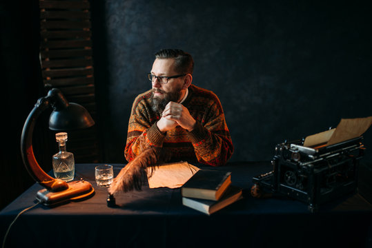 Bearded writer in glasses sitting at the table