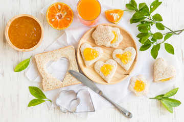 Orange jam with bread set on white rustic wooden table background