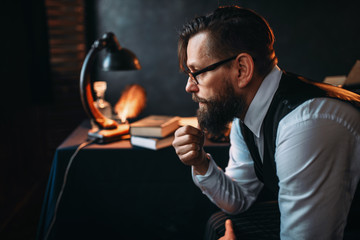 Bearded writer in glasses smoking a pipe