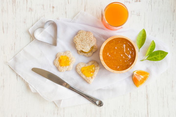Orange jam with bread set on white rustic wooden table background