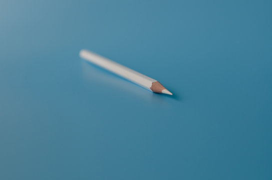 white pancil on a blue background