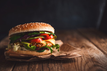 Delicious fresh homemade burger with chicken nuggets and avocado on a wooden table