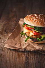 Delicious fresh homemade burger with chicken nuggets and avocado on a wooden table