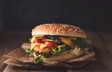 Delicious fresh homemade burger with chicken nuggets and avocado on a wooden table
