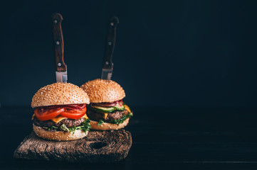 Two mouth-watering, delicious homemade burger used to chop beef. on the wooden table. The burgers...