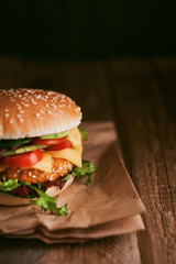 Delicious fresh homemade burger with chicken nuggets and avocado on a wooden table