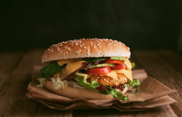 Delicious fresh homemade burger with chicken nuggets and avocado on a wooden table