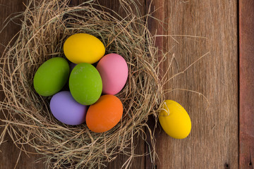 Easter eggs in nest on old wooden background