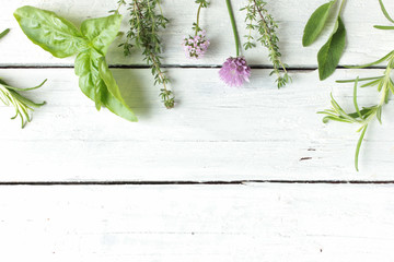 verschiedene frische grüne Küchenkräuter Kräuter essbare Blüten Tisch Weiß Top View