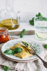 The man is cooking Ravioli with spinach and ricotta cheese