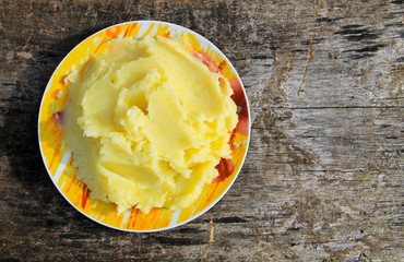 Mashed potatoes in a plate on rustic wooden table