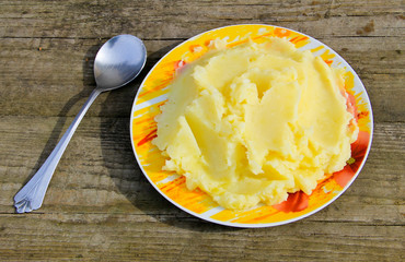 Mashed potatoes in a plate on rustic wooden table