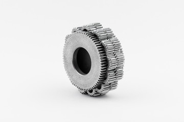 Isolated metal pinions gear. The iron gear on a white background. Pinions in the gearbox. Parts to the gear mechanism. Sprockets to clockwork. Shiny gear ready for assembly.