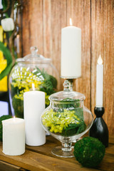 Candlestick with candle, mimosa in vase  and other elements of festive table wedding centerpieces decorations.